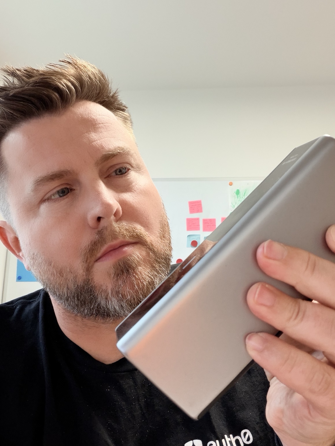 Sven betrachtet ein Technikprodukt in seiner Hand.